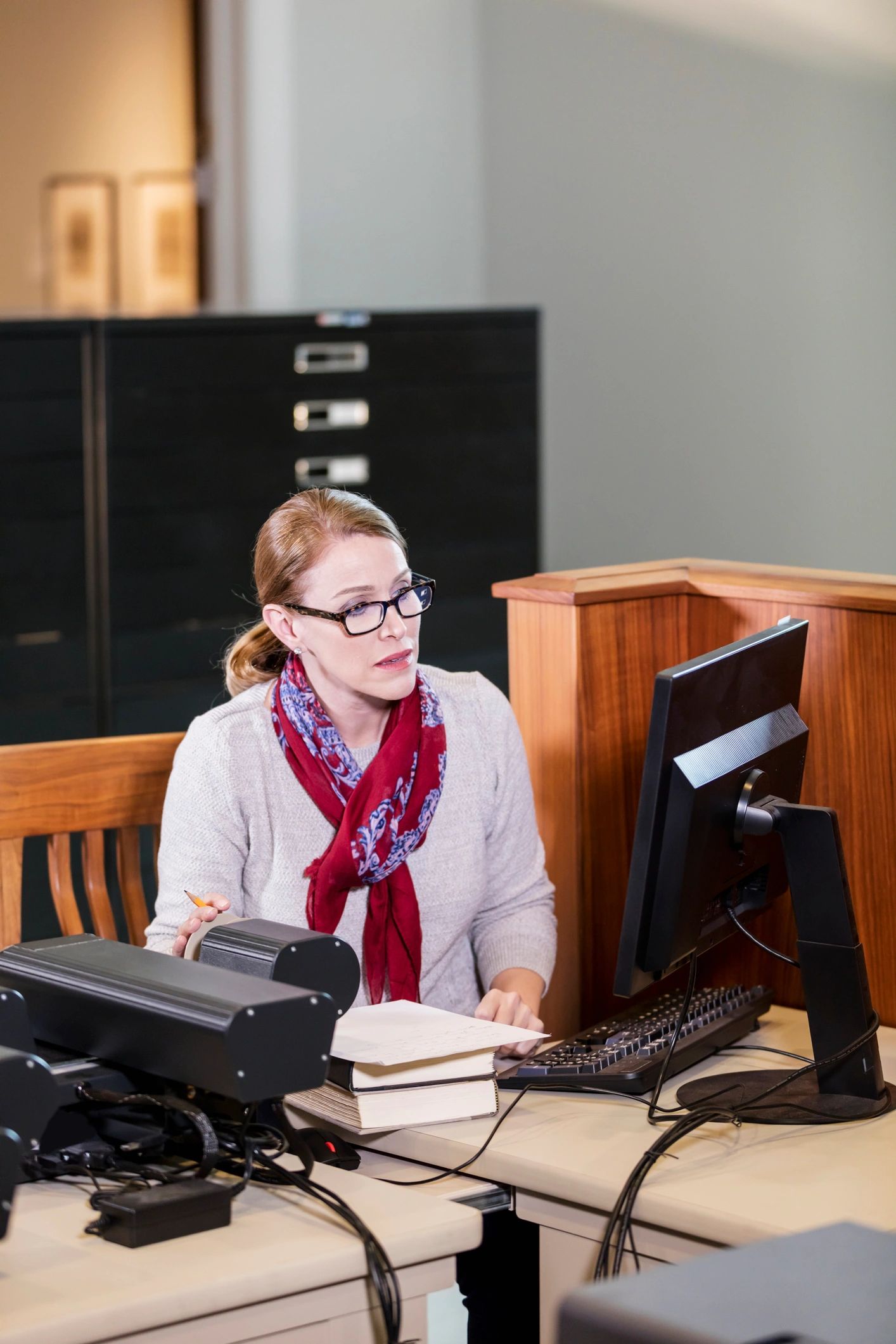 Researcher reviewing historical documents on microfiche in a library
